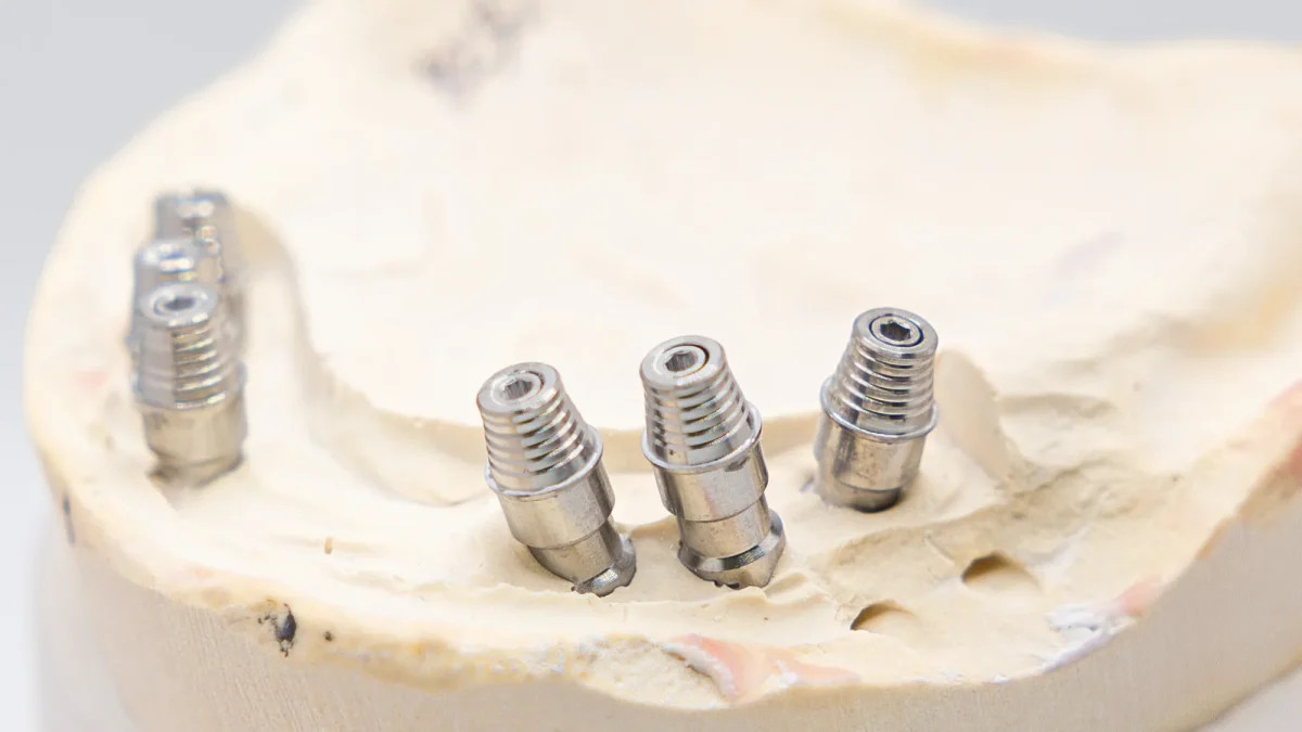Implant abutments standing at their placed angles on a master cast at the dental lab bench