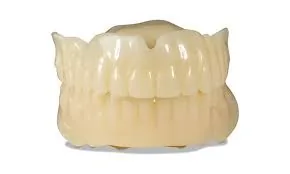 A complete upper denture with a full arch of monolithic acrylic teeth, photographed against a white background.