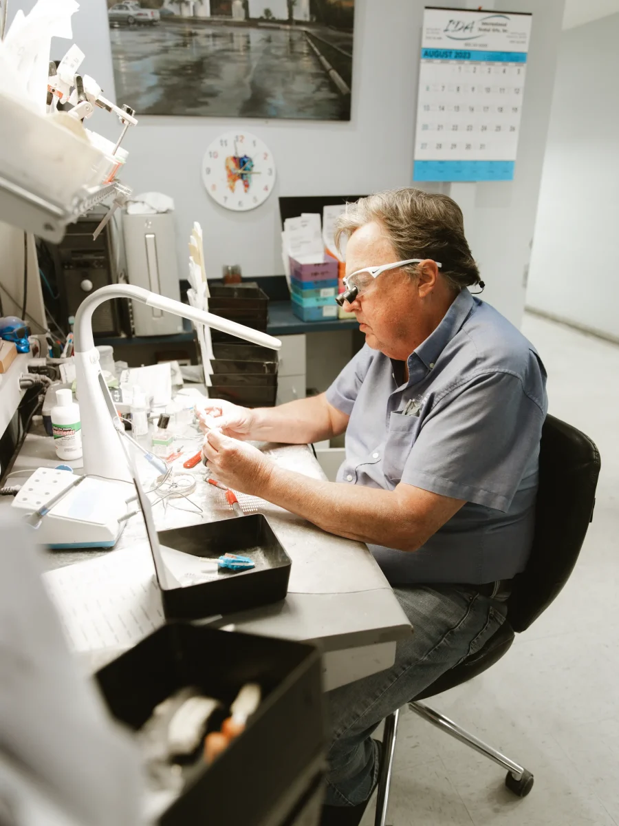 IDA technician working a case detail with pliers