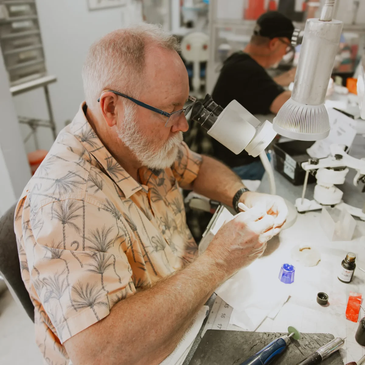 IDA technician at the microscope, focused on case detail
