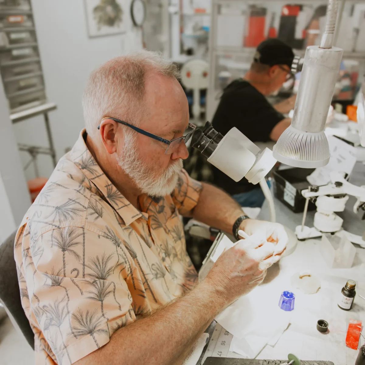 IDA technician working at the bench under a microscope